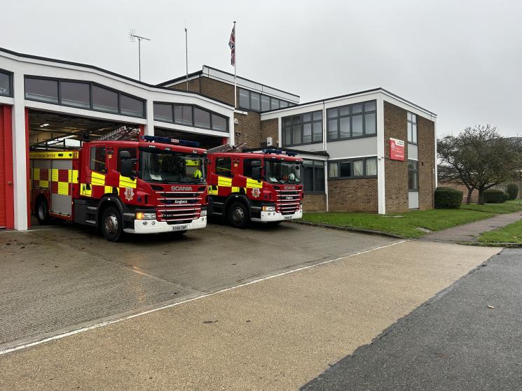 Brick fire station with two fire engines parked outside