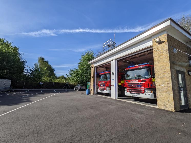 Two fire engines sat inside brick building with two open bay doors