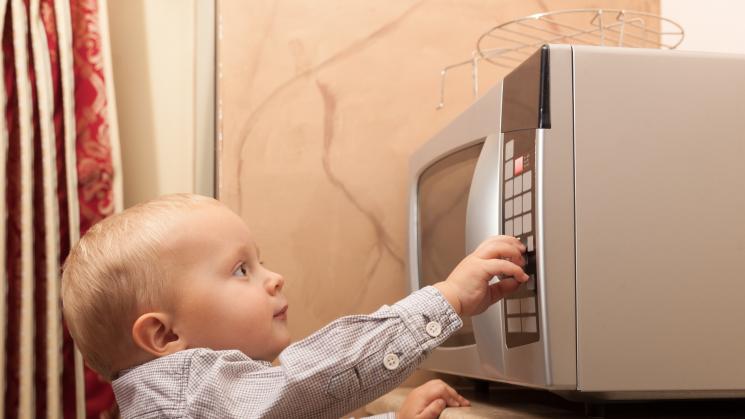 Child turning on a microwave