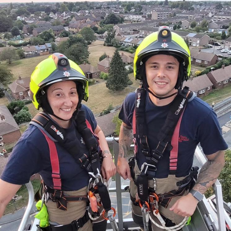 two firefighters on an aerial ladder platform