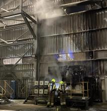 Firefighters working to extinguish a fire in a machine