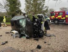 Black car on its side following a collision