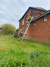 Firefighters extinguishing a roof fire