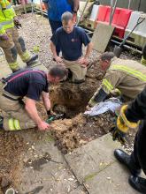 Firefighters digging around the underground pipe