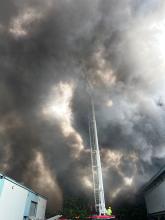 Firefighters using an Aerial Ladder Platform to extinguish an industrial unit fire