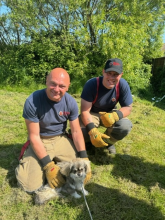 Two firefighters with a dog they rescued