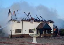 Smoke coming from the roof of a house after a fire has been extinguished