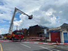 fire engine and tall ladder over a damaged building on fire