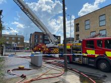 fire engine and tall ladder next to a building on fire