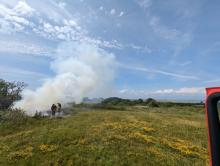 Firefighters working to extinguish a grass fire
