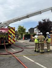 Crews using an Aerial Ladder Platform to extinguish the roof fire 