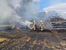 Firefighters at the scene of a tractor fire that spread to a field