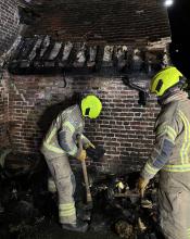 Two firefighters survey the damaged porch