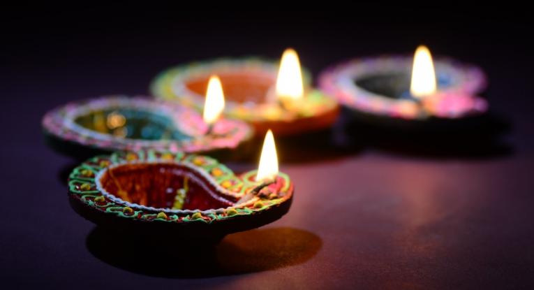 Four brightly coloured candles lit to celebrate Diwali