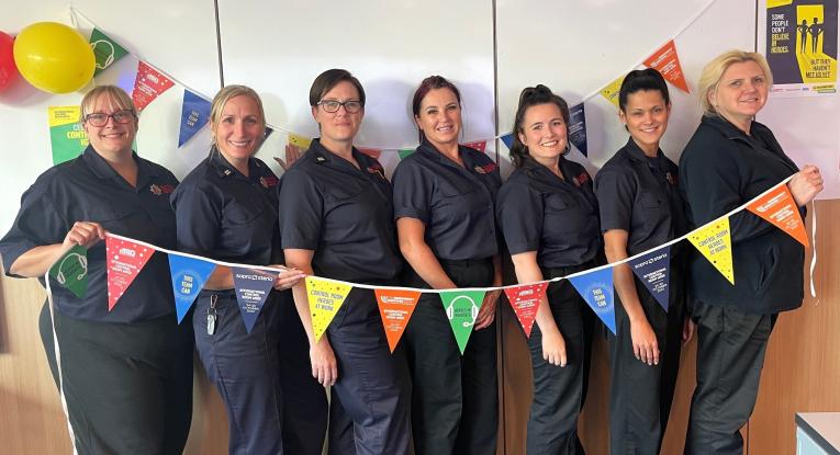 Green Watch Control team members Kristin, Vanessa, Gemma, Kelly, Johdi, Samantha and Rochelle holding multi-coloured bunting
