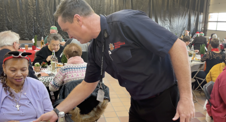 Assistant Chief Fire Officer Chris Parker handing a guest her dinner at the Rayleigh Christmas lunch 