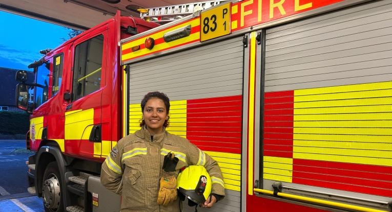 Firefighter Keegan Johnson in front of a fire engine at Stansted Fire Station